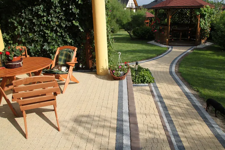 A garden path and patio behind a home